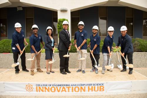 President of CSUF, former dean of ECS and students holding shovels