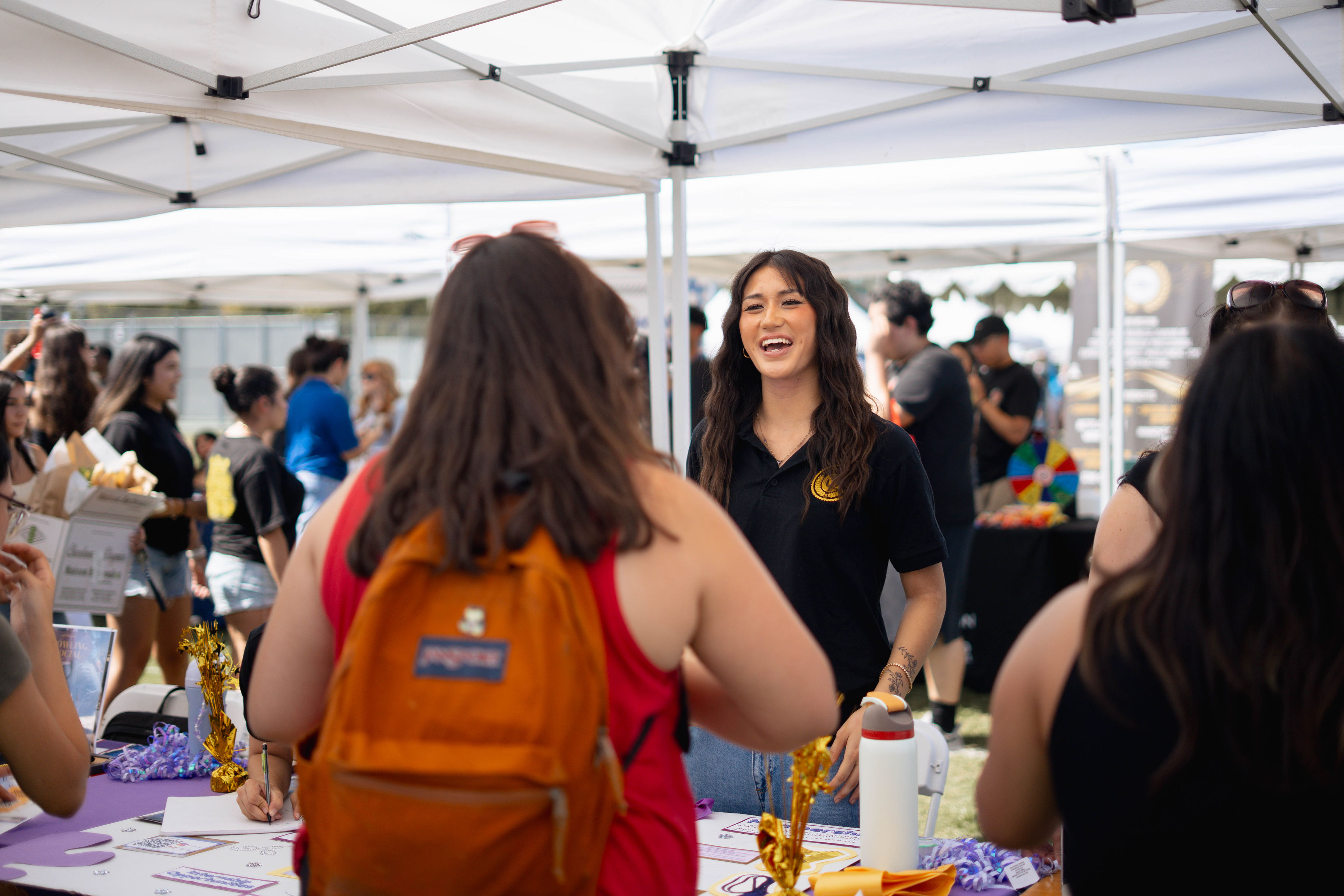 Student smiling as they table to other students