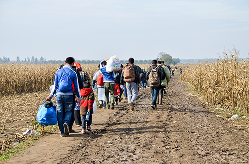 migrants walking along a road, symbolizing Explore Core's first offering, Migrant Lives