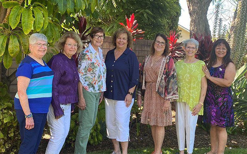 Seven women standing outside.