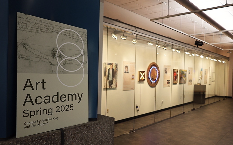 Artwork hung in a glass covered display case.