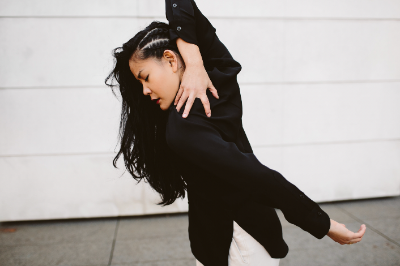 Woman bending her arm around her body.