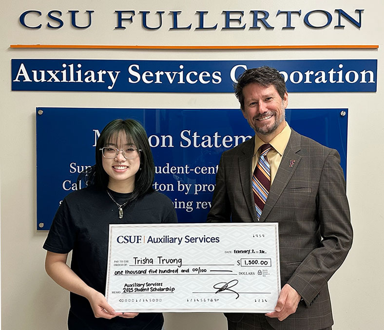 Trisha receives a check worth $1,500 from ASC Executive Director Charles Kissel