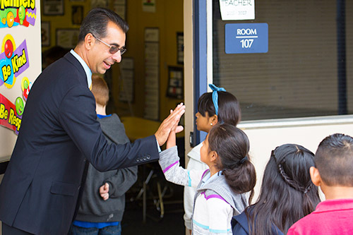 Elementary school principal greeting students at the door