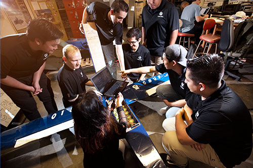 A group of students working on a Mars rover prototype