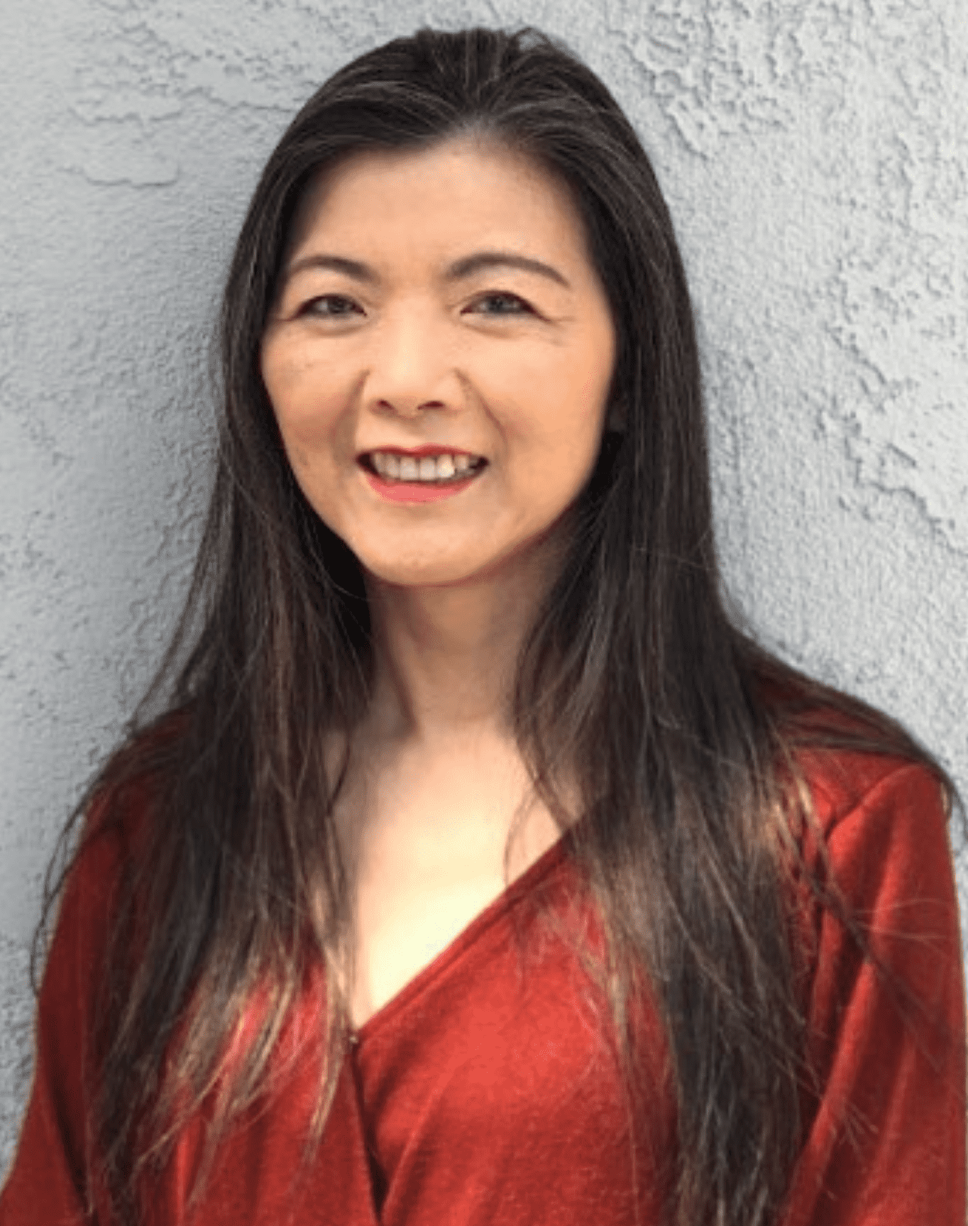 A photo of an Asian language instructor smiling at the camera.