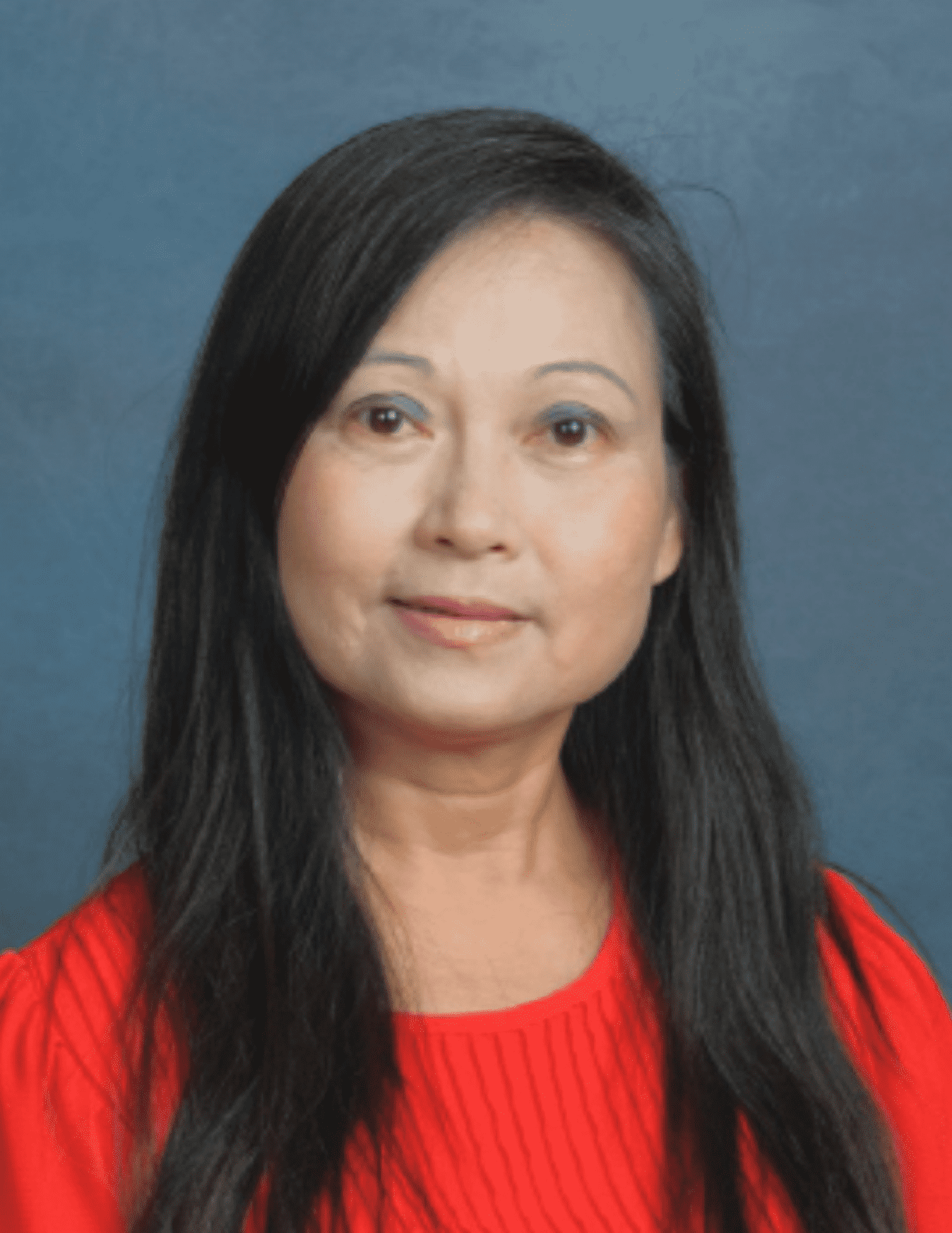 An Asian language instructor smiles for the camera.