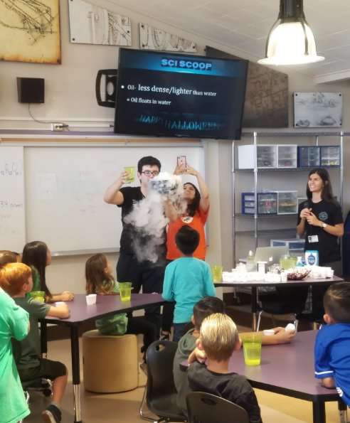 Two CSUF students conducting experiment in front of elementary students in classroom
