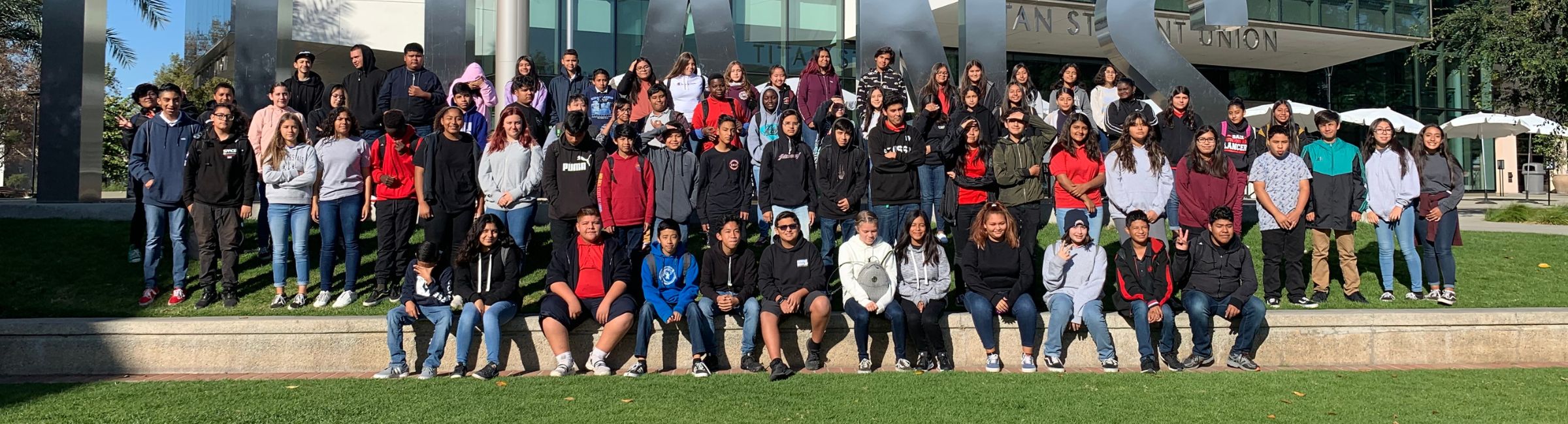 Group of stuents standing in front of Titan block letters