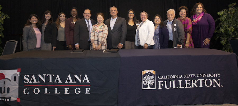 Cal State Fullerton staff alongside Santa Ana College staff pose for a picture during in an event celebration of a partnership contract between the two schools. 