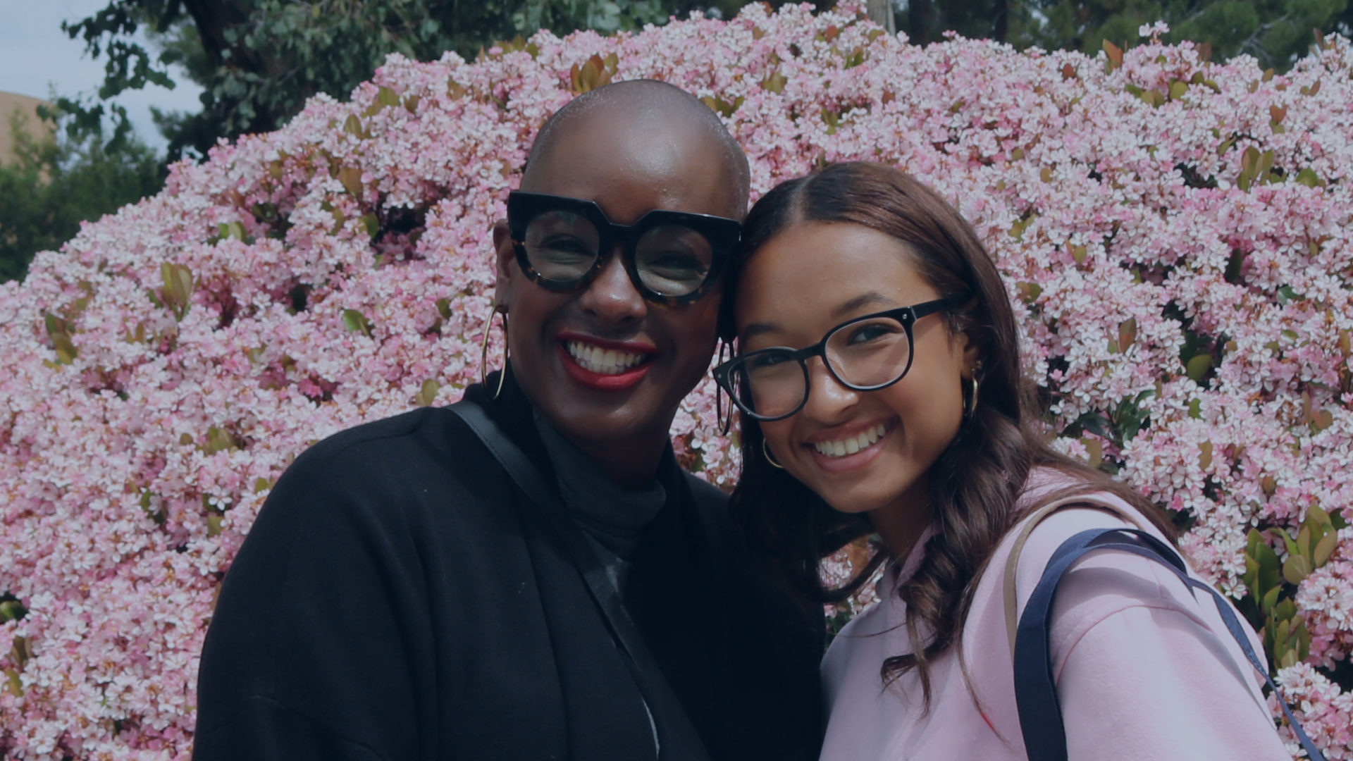 A mother and daughter pose for the camera with a blue overlay