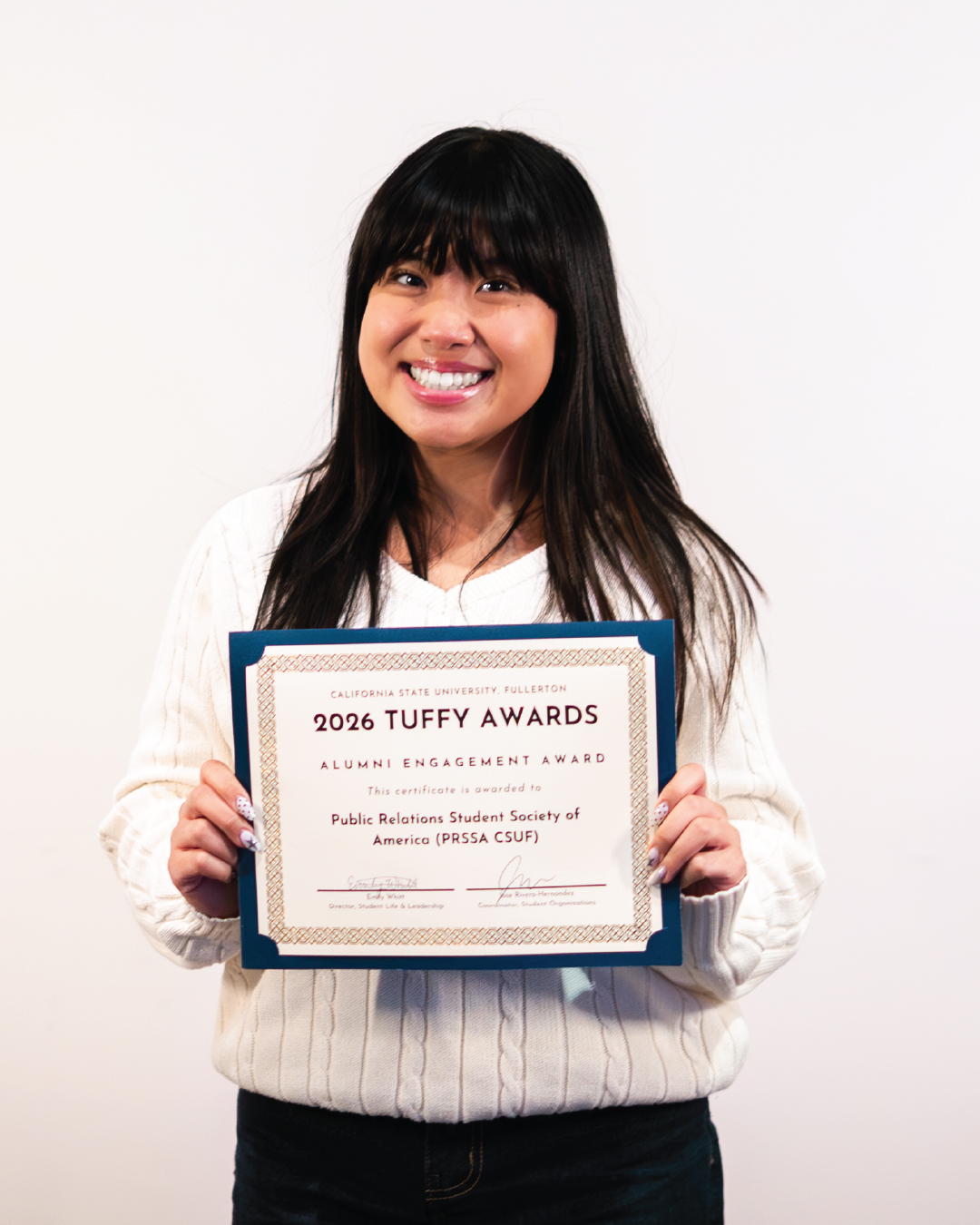 Student holding an award for Alumni Engagement Award