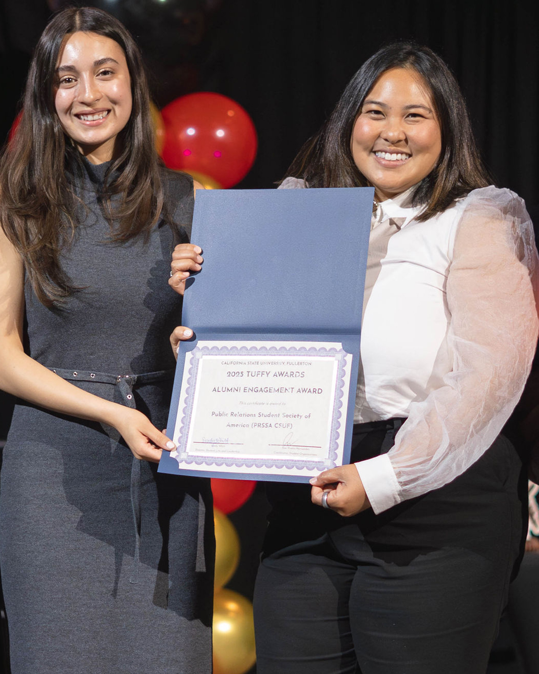 Students holding an award for Alumni Engagement