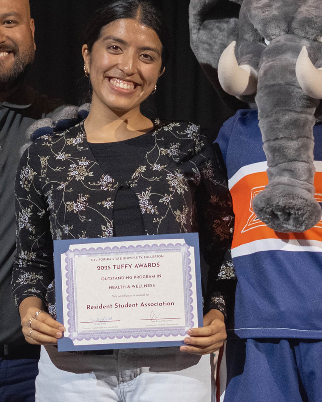 Student holding an award for Outstanding Program in Health and Wellness