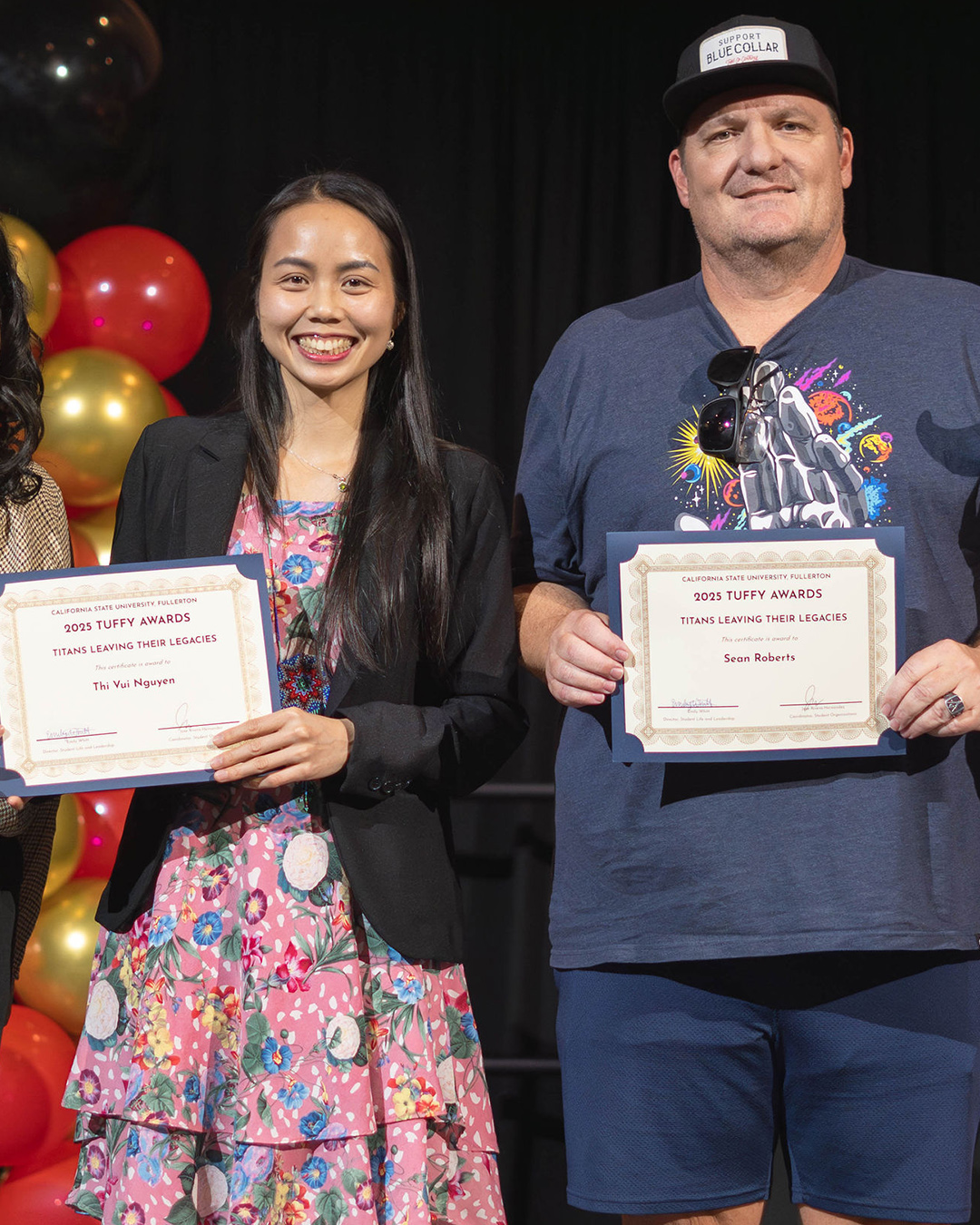 Two students holding an award for Titans Leaving Their Legacies
