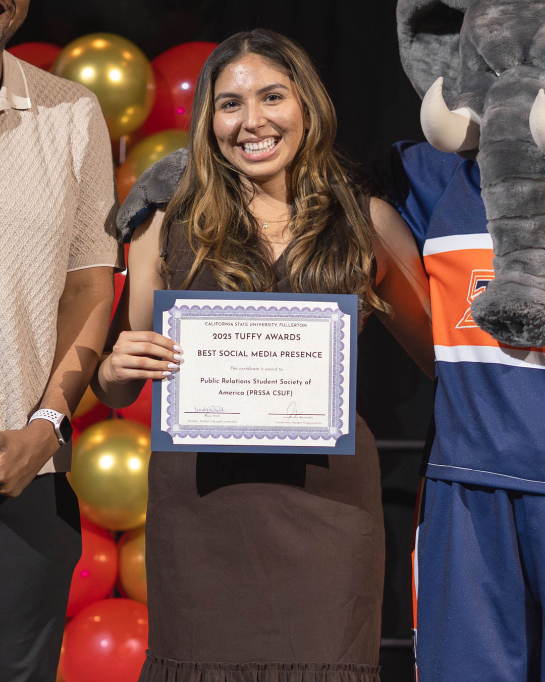 Student holding an award for Best Social Media Presence