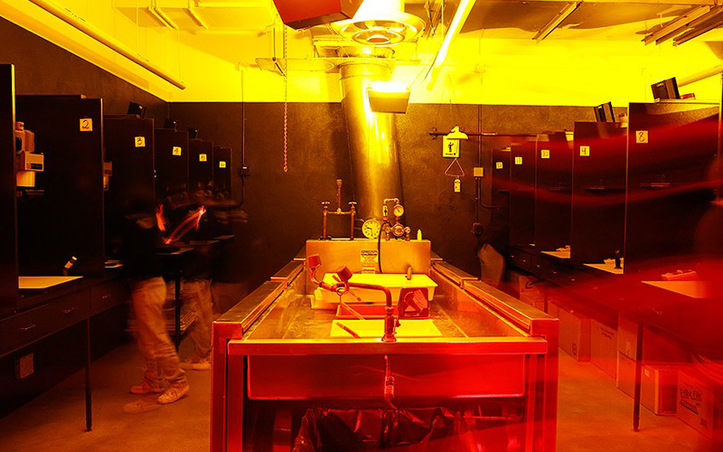 Students developing film in a darkroom.