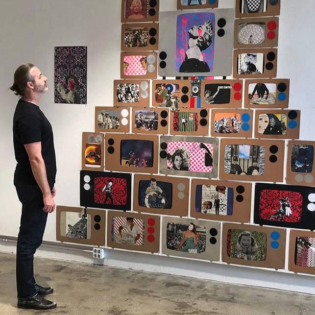 man looking at a display of stacked drawings