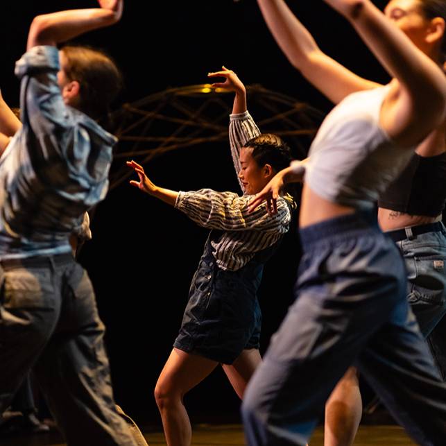 Three dancers gesticulating with their hands.