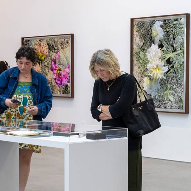Two women looking at art objects on a table.