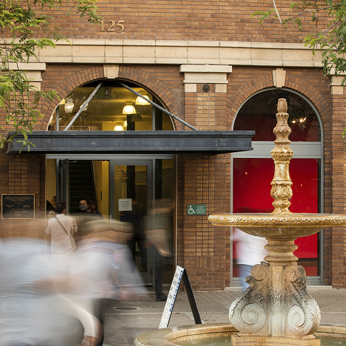 Front of a brick building with passersby.