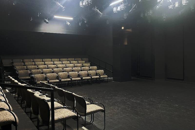 Small theatre space with rows of seats on the sides.