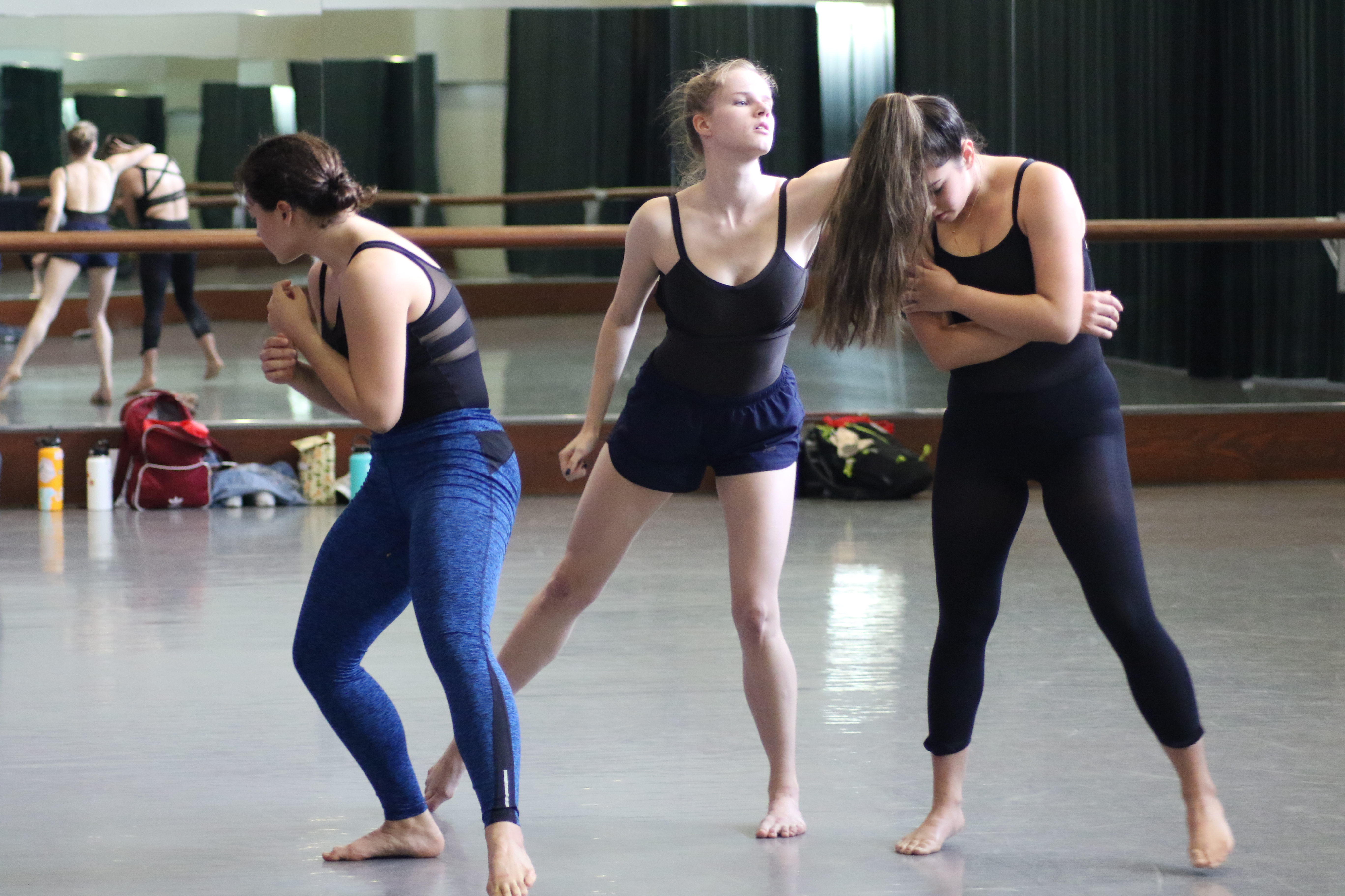 3 dancers rehearsing in a dance studio.