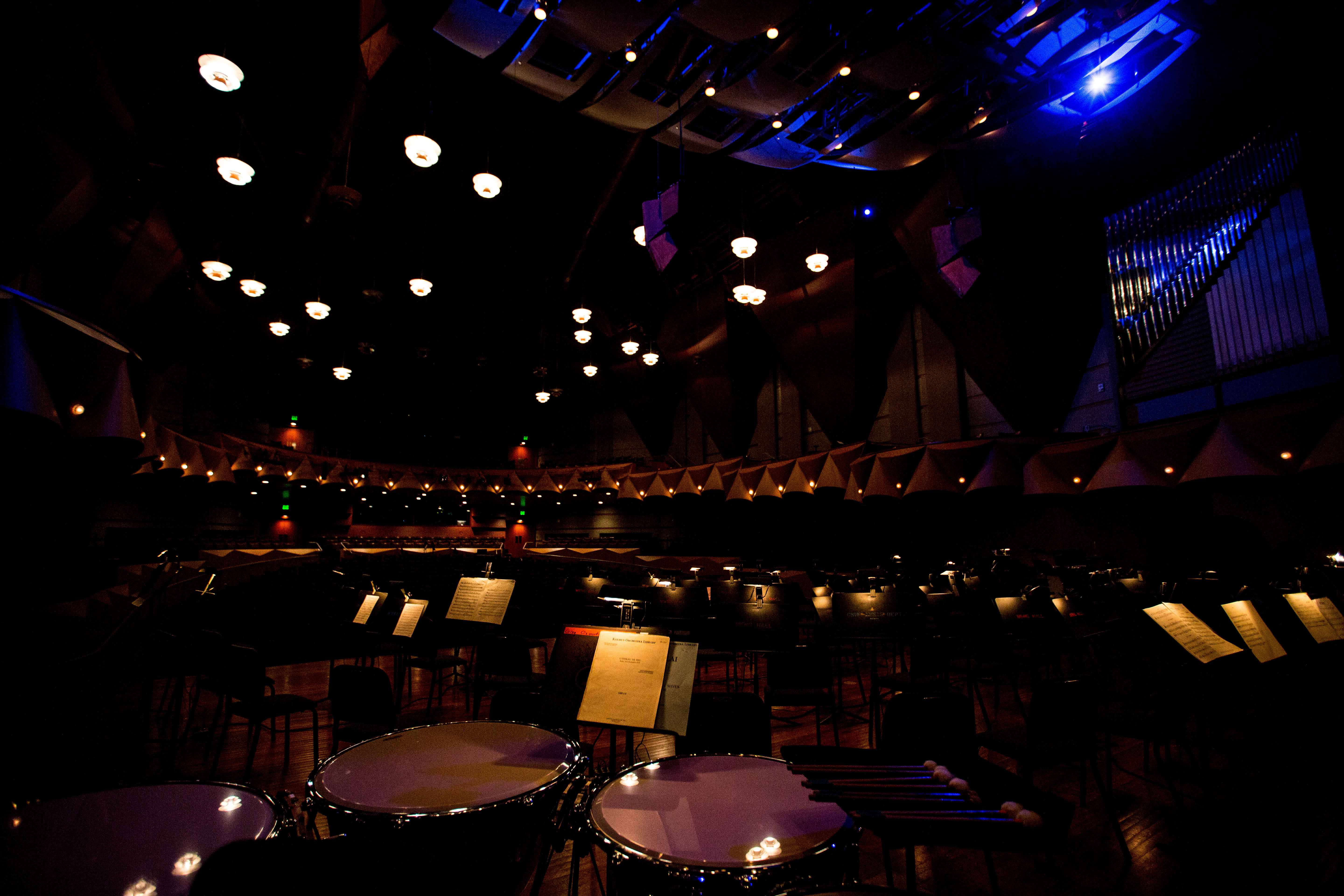 Music stands on a dramatically lit stage.