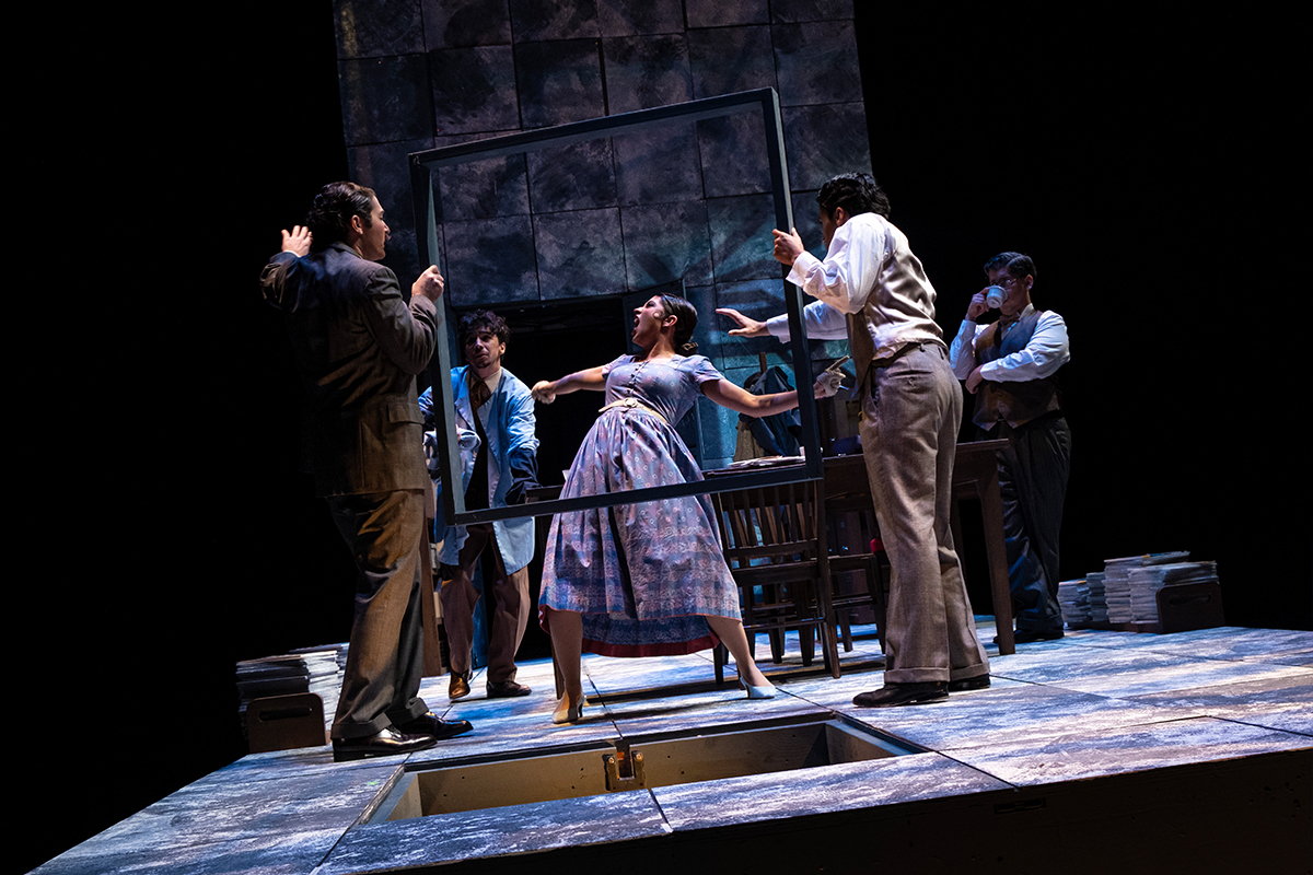 Tilted stage with actors.