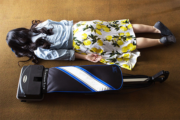 Woman face down on floor next to vacuum
