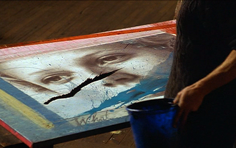 Figure in front of a canvas on the floor.