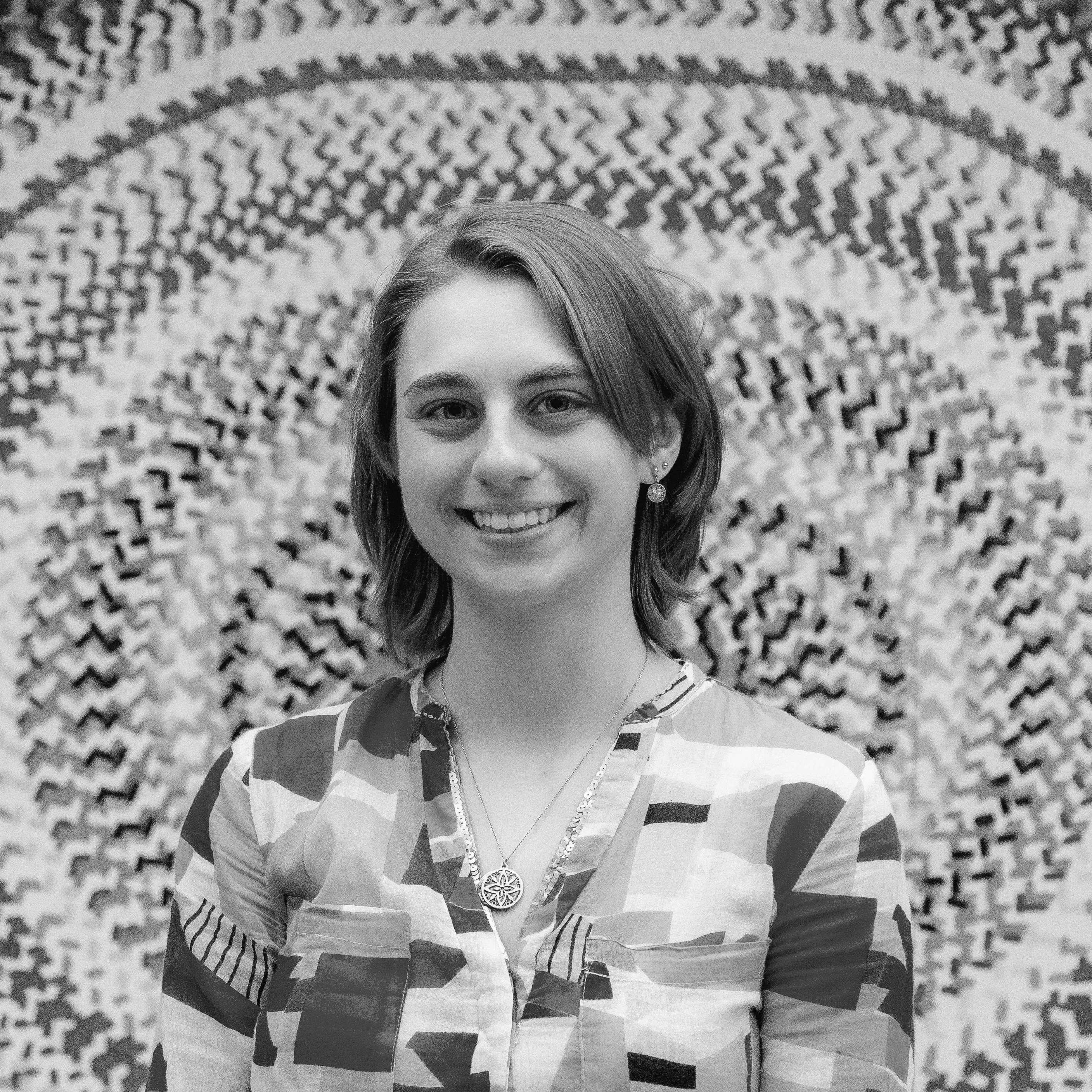 Smiling woman in front of patterned fabric