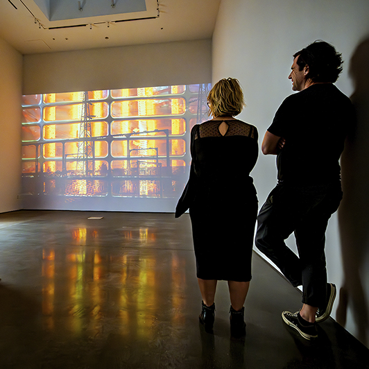 Two people looking at a projection on a wall.