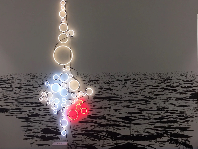 Neon sclupture hung on a wall.