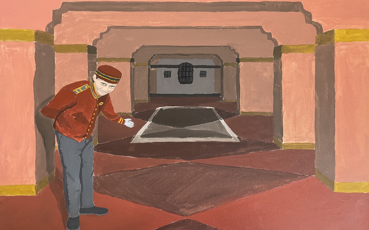 Bellhop gesturing towards a long hallway.