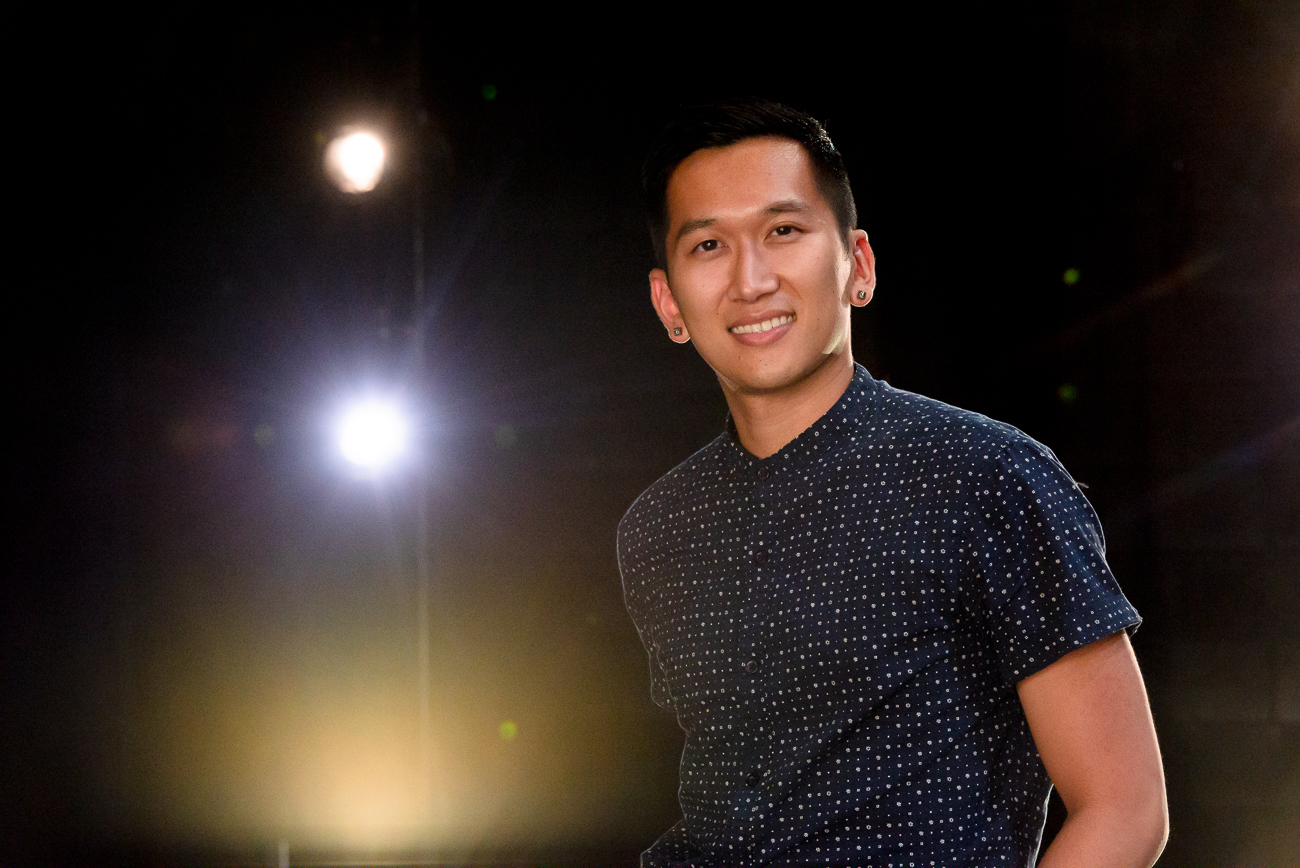 Man with stage lights behind him