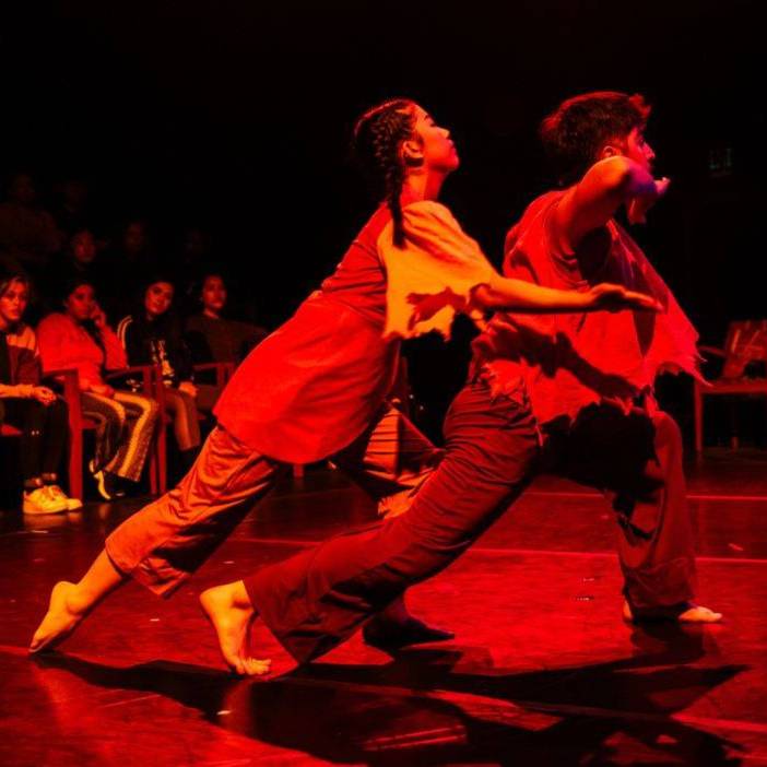 Male and female dancer under red lights.
