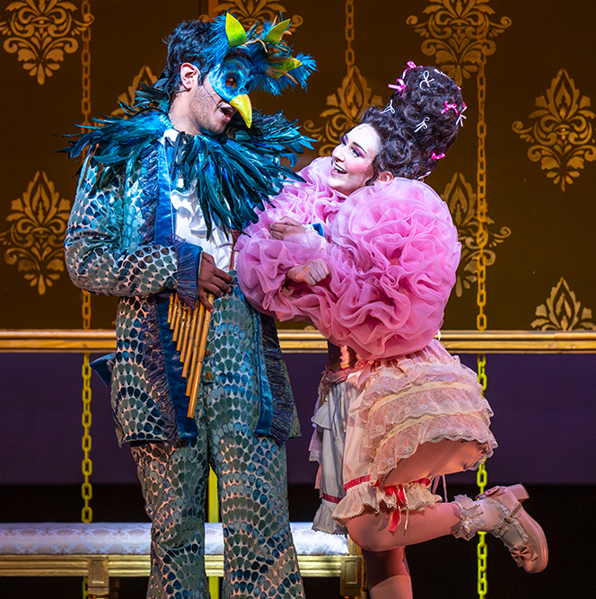 Man and woman in extravagant costumes singing.