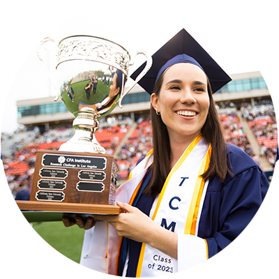 Graduating student hoisting CFA Institute trophy