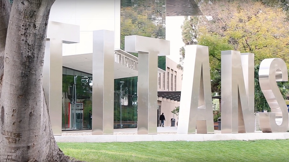 Large metal letters spell Titans on campus