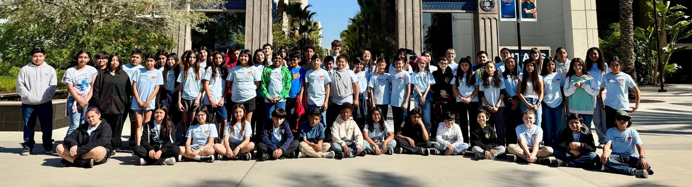 Group of students standing outdoors in front of Cal State Fullerton