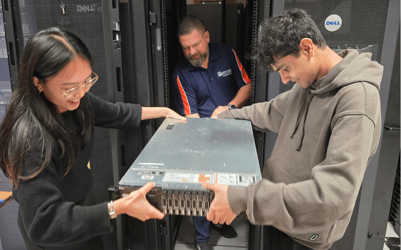Cybersecurity students with a computer drive
