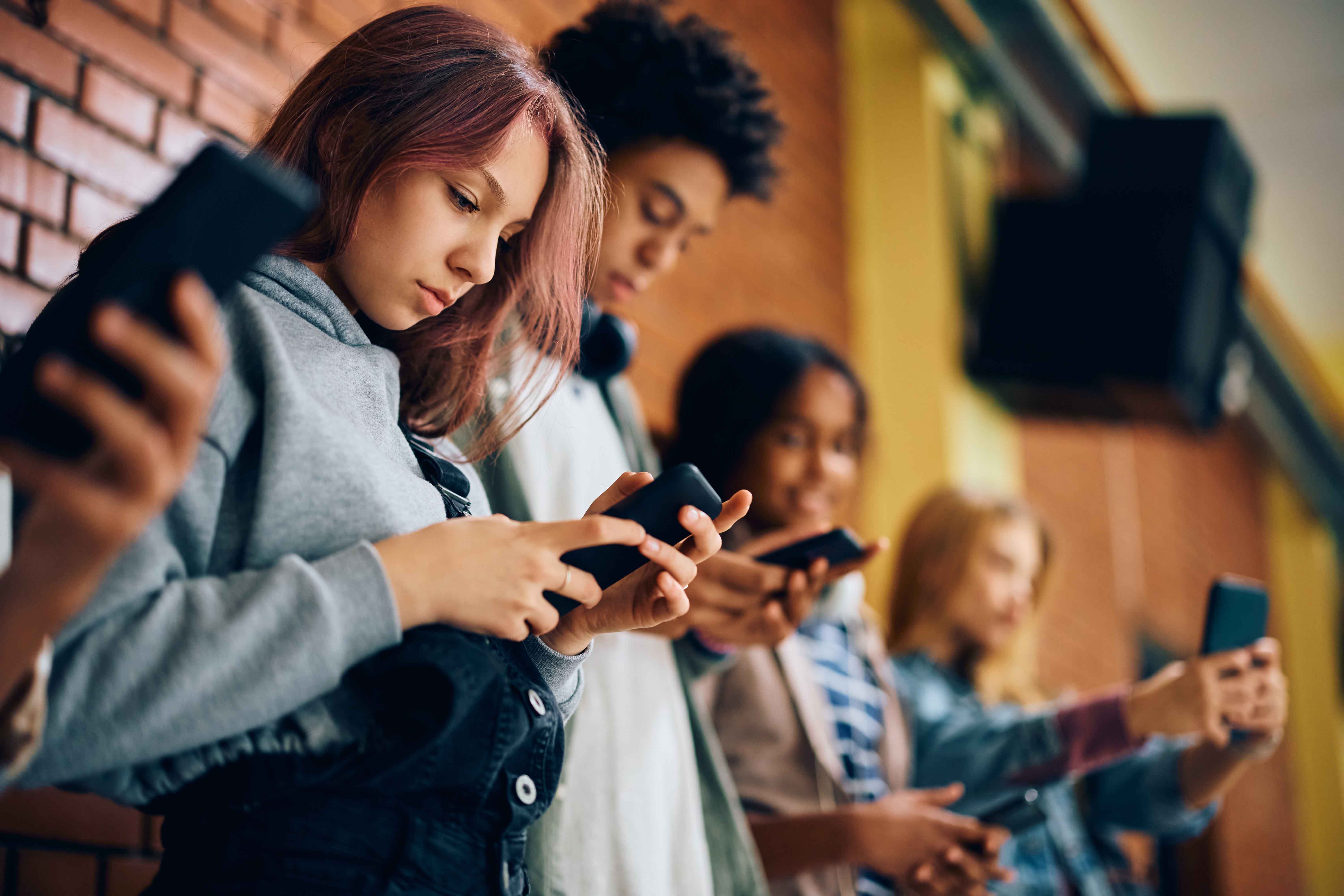 group of teenagers with cell phones