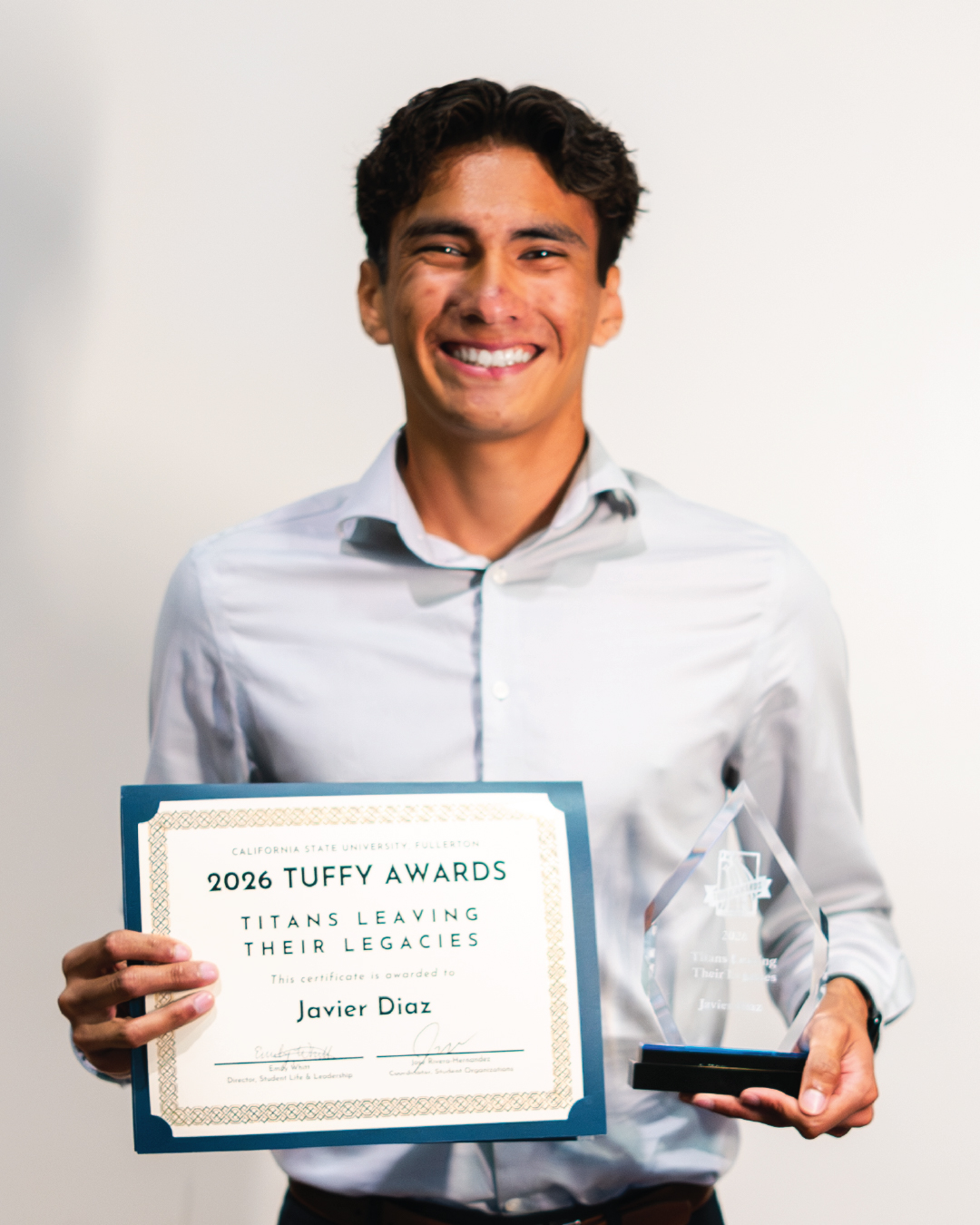 Student holding an award for Titans Leaving Their Legacies
