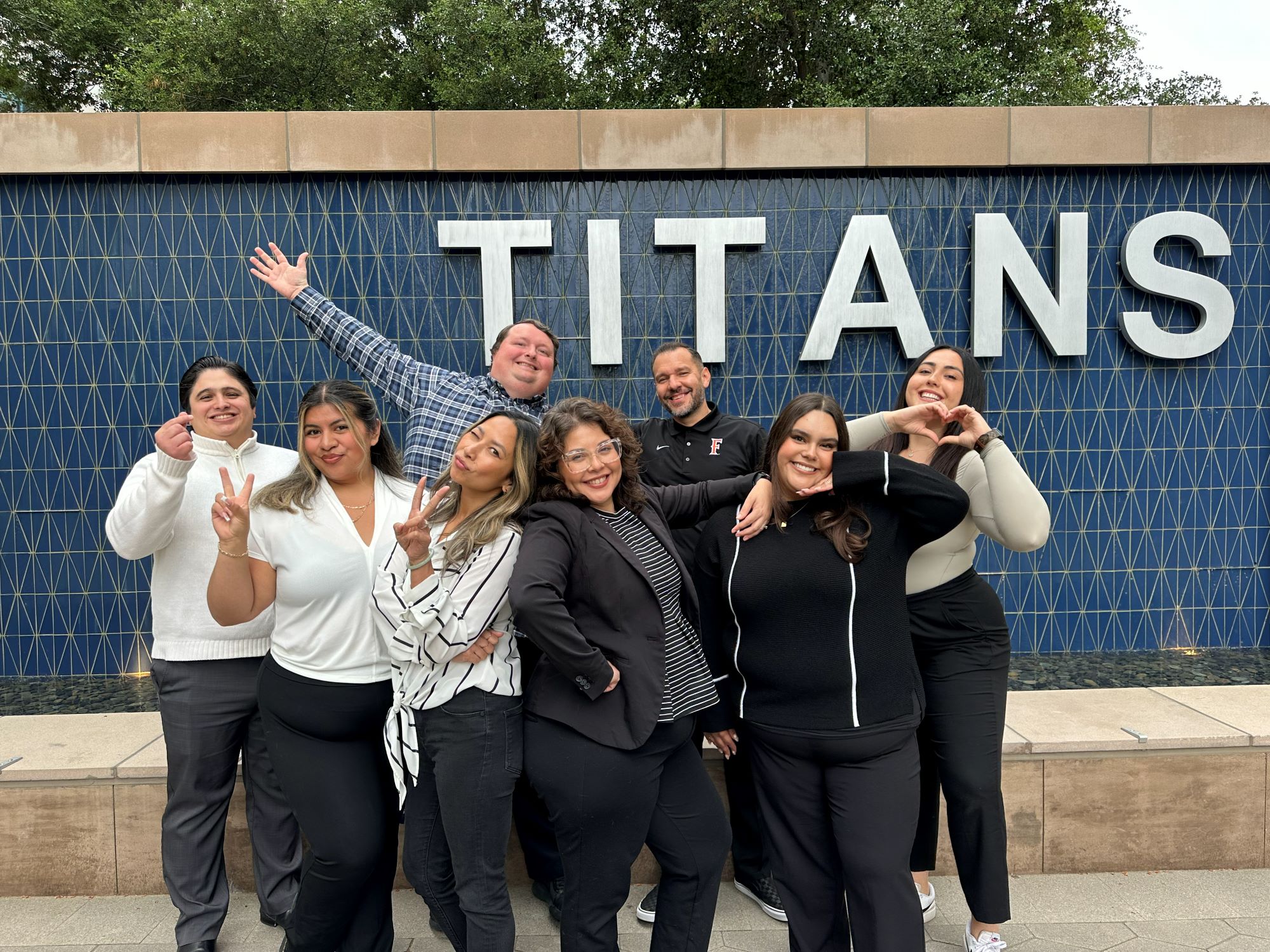 The UAAC team members pose in front of the TITANS fountain outside the Pollak Library.