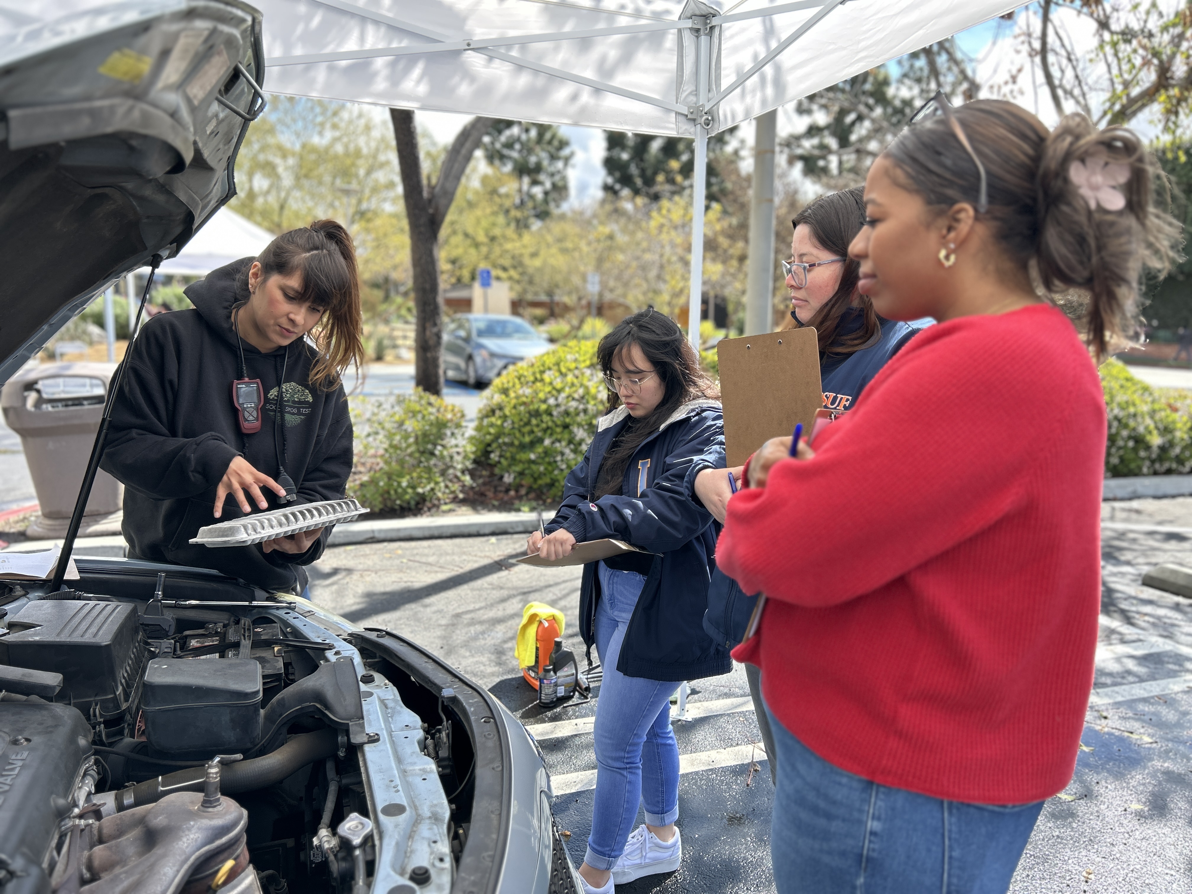 women working on a car